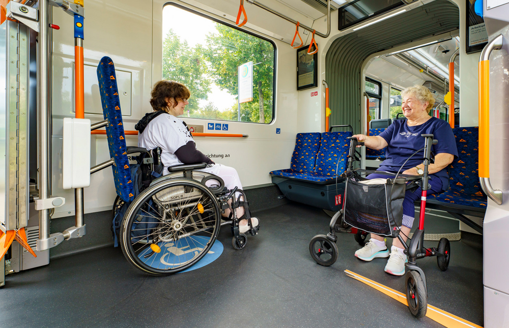 Multifunktionsflächen in der Rhein-Neckar-Tram zum sicheren Abstellen von Rollstühlen und Rollatoren vorne und für Kinderwagen und Fahrräder hinten.