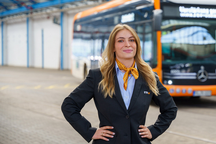 Eine Busfahrerin der Rhein-Neckar-Verkehr GmbH (rnv) steht vor einem elektrisch betriebenen eCitaro-Bus.