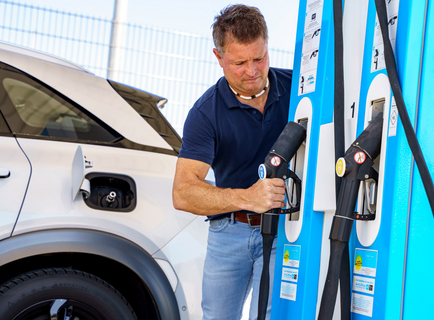 Ein Mann betankt einen Pkw an der öffentlichen H2-Tankstelle beim Gelände des rnv-Betriebshofs in Heidelberg-Wieblingen mit Wasserstoff.